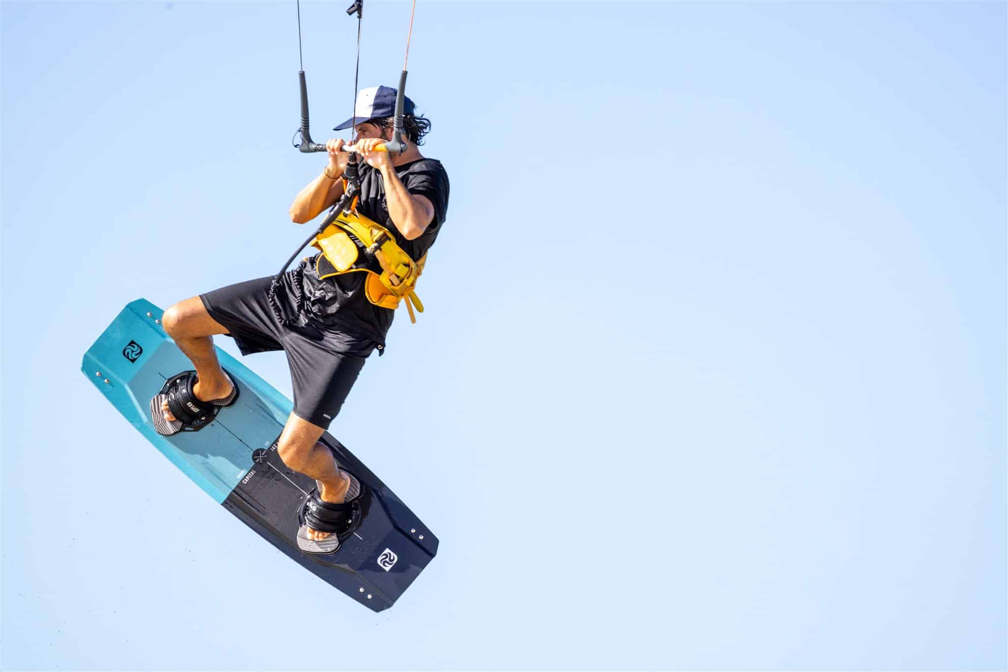 Fotógrafo profesional capturando kitesurfista en la playa.
